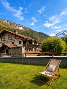 a chair sitting on the grass in front of a house at Le Petit Refuge in La Thuile