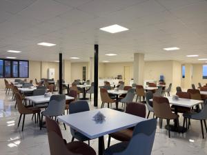 a dining room with tables and chairs and tablesktop at Hotel Royal Georgia 2 in Batumi