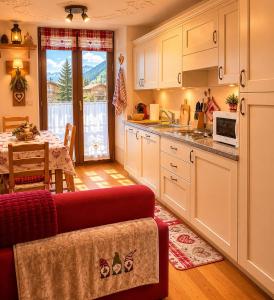 a kitchen with a red couch and a table with a dining room at Le Petit Refuge in La Thuile