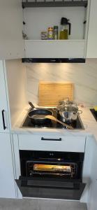 a stove top oven with two pots and pans on it at Cozy Tiny-House - ComfyHome Apartments in Stuttgart