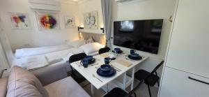 a living room with a white couch and a tv at Cozy Tiny-House - ComfyHome Apartments in Stuttgart