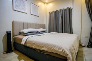 a bedroom with a bed with two pillows on it at Staycation by ALCD in San Mateo