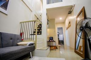 a living room with a couch and a staircase at Staycation by ALCD in San Mateo