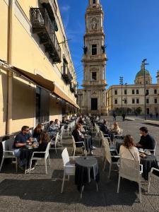 a group of people sitting at tables in front of a building at Hotel Santuario Pompei in Pompei