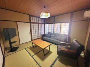 a living room with a couch and a table at MIYABI stay house in Tamana