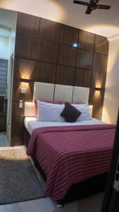 a bedroom with a large bed with a large wooden headboard at Hotel 101 & Apartments in Karsana