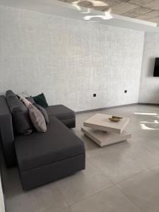 a living room with a couch and a coffee table at Апартамент САМИ 102 in Dobrich