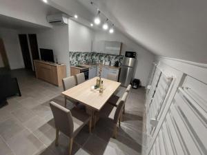 a kitchen with a wooden table and chairs in a room at Gilbert Apartman in Doboz +4 photos