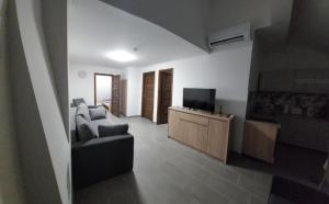 a living room with a couch and a television at Gilbert Apartman in Doboz