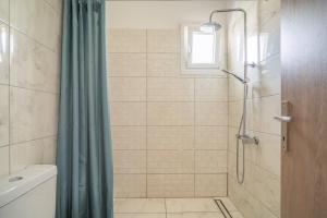 a shower with a blue shower curtain in a bathroom at Perseus in Cape Sarakiniko in Argostoli +18 photos