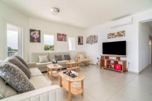 a living room with a couch and a tv at Perseus in Cape Sarakiniko in Argostoli