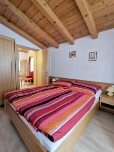 a large bed in a bedroom with wooden ceilings at Landhaus Nageler in Westendorf
