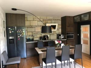 a kitchen with a table and chairs and a refrigerator at Aavik Apartment in Kuressaare