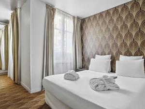 a hotel room with a bed with towels on it at Mercure Paris Opéra Faubourg Montmartre in Paris +92 photos