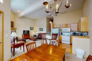 a kitchen and living room with a table and chairs at Wildernest Gore Trail Condo in Silverthorne
