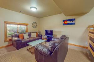 a living room with a couch and a table at Spruce Chalet in Granby