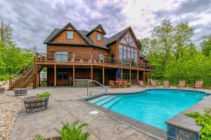 a log house with a pool in front of it at Mountain Estate Main House in Newry