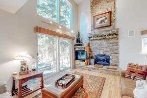 a living room with a stone fireplace and a couch at Mountain Breeze in Breckenridge