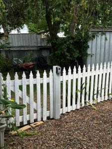 a white picket fence in front of a yard at The Hunter Studio in Cessnock +1 photo