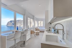 a white kitchen with a view of the ocean at Blue Haven - Ocean View Penthouse with private jacuzzi and community pool in Acantilado de los Gigantes