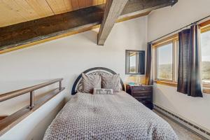 a bedroom with a bed in a room with windows at Emerald Views at the West in Steamboat Springs +42 photos