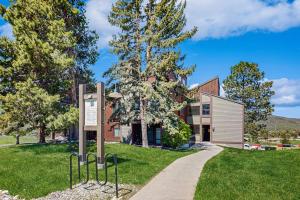 a building with a sign in front of a path at Emerald Views at the West in Steamboat Springs