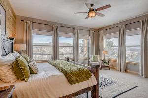 a bedroom with a bed with a ceiling fan and windows at Cutbow Lodge in South Fork