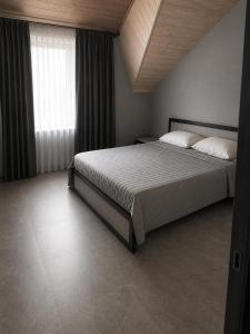 a bedroom with a large bed and a window at Graphite House in Kyiv