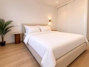 a bedroom with a large white bed and a potted plant at YBH Ocean Boutique in Vigo