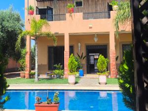 a house with a swimming pool in front of it at Villa khaddouj Marrakech in Marrakesh