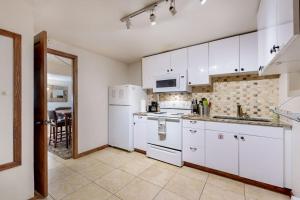 a kitchen with white cabinets and white appliances at Eagles Nest in Vail