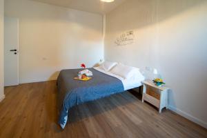 a bedroom with a bed with a blue blanket and a table at Petra's House in Lenno