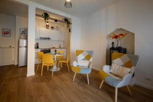 a living room with a table and chairs and a kitchen at Petra's House in Lenno