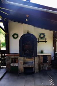 an outdoor brick oven with wreaths on a wall at Behív-Lak in Medişoru Mic