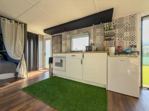 a kitchen with white cabinets and a green rug at Holenderka nad Szelmentem in Jeleniewo +10 photos
