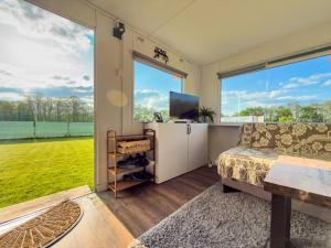 a living room with a couch and a large window at Holenderka nad Szelmentem in Jeleniewo