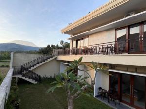 a house with a balcony with tables and chairs at Qiana House in Manggis +34 photos