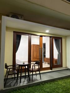 a dining room with a table and chairs and a window at Qiana House in Manggis