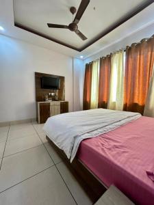 a bedroom with a large bed with a ceiling fan at Laksh hotel,Proprietor Dilbag in Kurukshetra