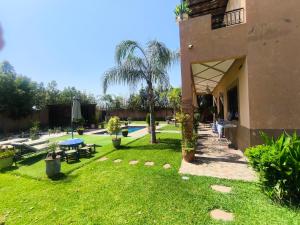 a yard with a swimming pool and a house at Villa khaddouj Marrakech in Marrakesh