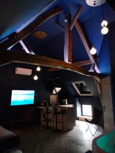 a room with a blue ceiling with a table and a tv at calme et volupté in Maxilly-sur-Saône