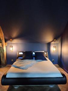 a bedroom with a bed with blue walls and lights at calme et volupté in Maxilly-sur-Saône +12 photos