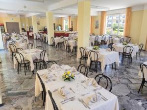 a banquet hall with white tables and chairs at Hotel Conti in Rimini