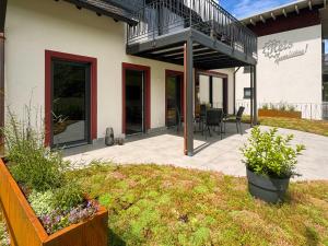 a patio of a house with a balcony at Wohnen am Weingut - Über den Fässern in Briedel