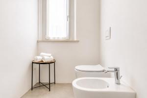 a white bathroom with a toilet and a sink at Amare Suite & Apartments in Bellaria-Igea Marina +57 photos
