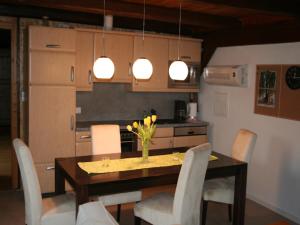 a kitchen with a dining room table with white chairs at Ferienwohnungen Am Nussbaum in Saalfeld +1 photo
