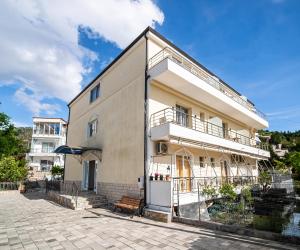 a large white building with a bench next to it at Vourtaréa Guesthouse in Himare