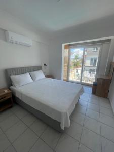 a bedroom with a large bed and a large window at çam otel in Fethiye