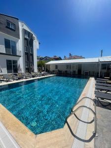 a large swimming pool with chairs and a building at çam otel in Fethiye
