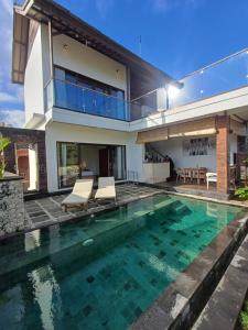 a villa with a swimming pool and a house at Green Bowl Beach Villas in Uluwatu